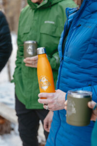Water bottle and insulated mug held by couple