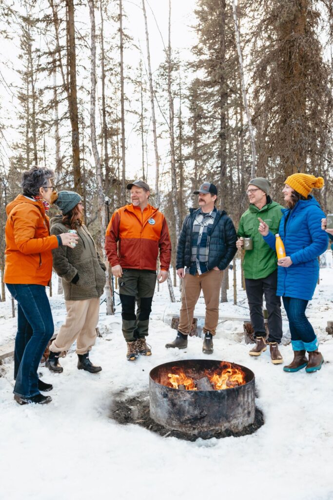 Wedding guests gathered at Bluewater Basecamp near Anchorage, Alaska, enjoying a private event space with on-site lodging. Photo credit: Lena Lee Photography